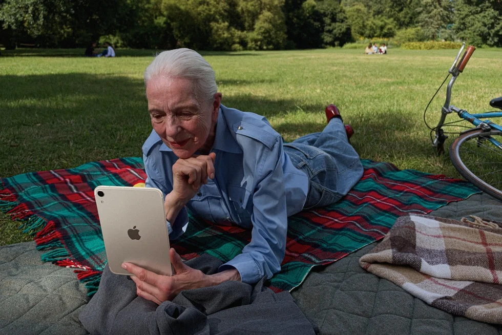 Personne utilisant un iPad mini sur une couverture à l'extérieur